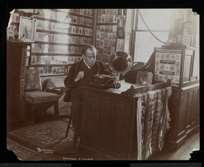Marshall P. Wilder escuchando un disco en una victrola en su oficina, 1898-99 de Byron Company